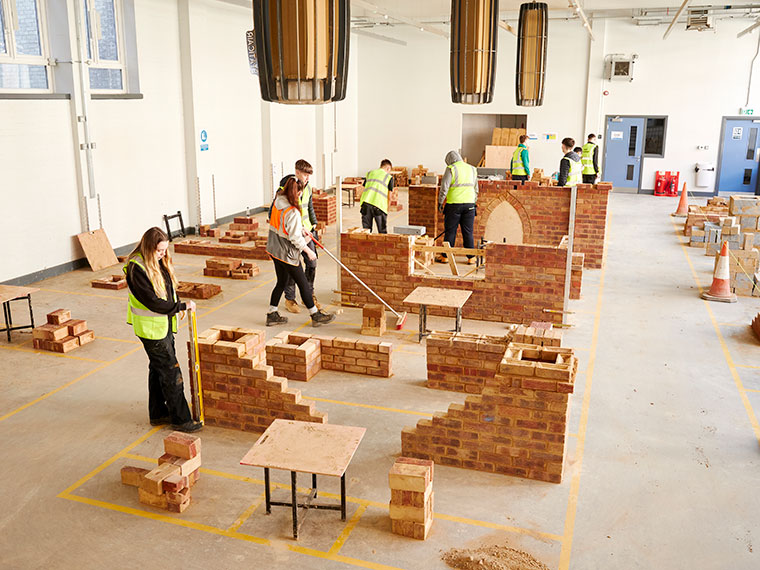 Bricklaying students working on building brick walls in the construction centre