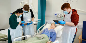 Students by a hospital bed in the health suite at DVC