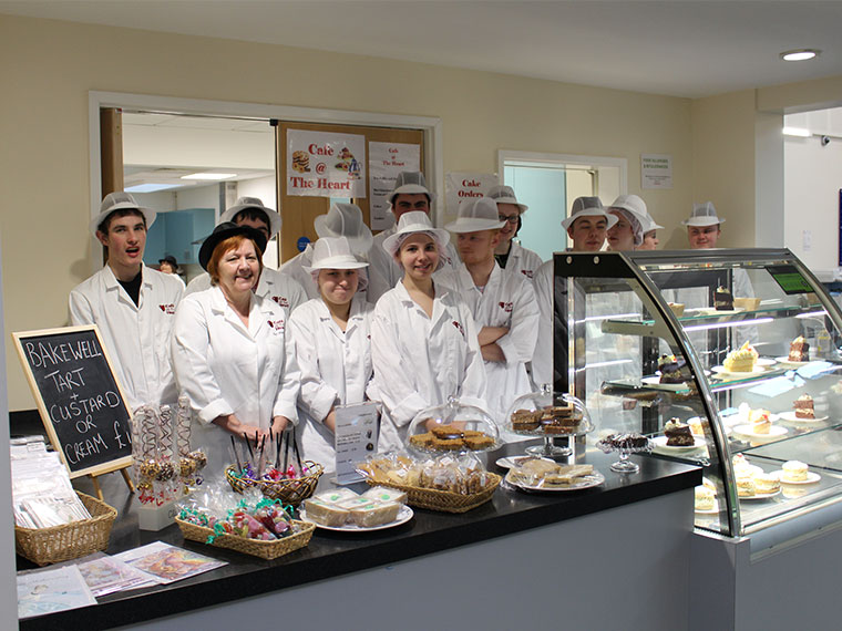 Students stand in their cafe which has earned a 5 star hygiene rating.