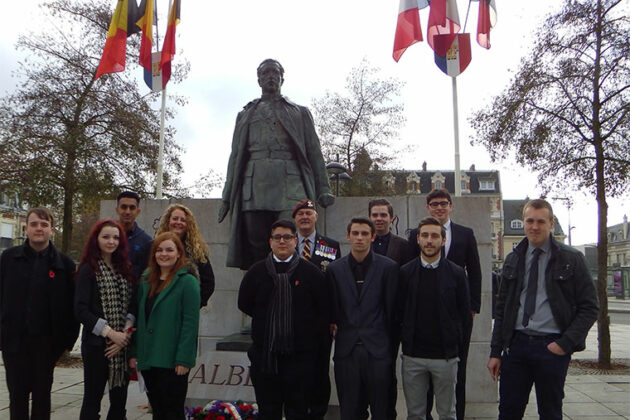 A group of students in front of the King Albert of Belgium statue.