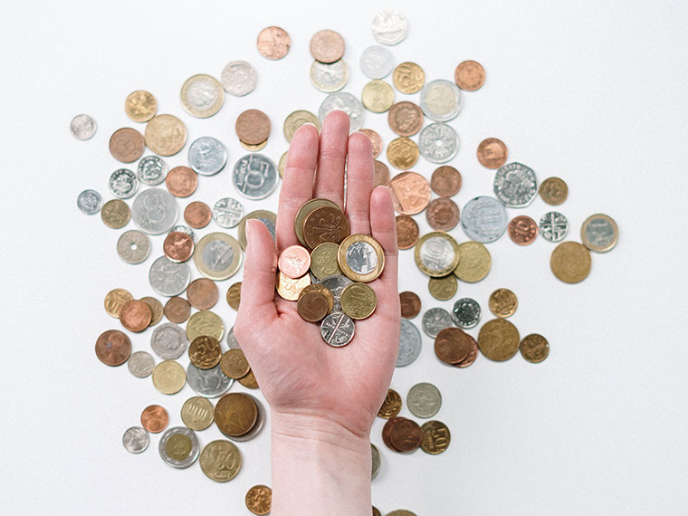 A hand holding coins