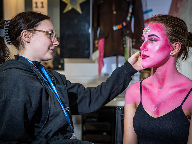 A media make up student applying make up to someone