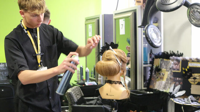 A student working on a hair style during the Intercollege 2025 competition
