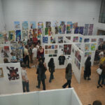 Rotherham College's creative showcase 2025 - People looking at student's artwork hung on the wall