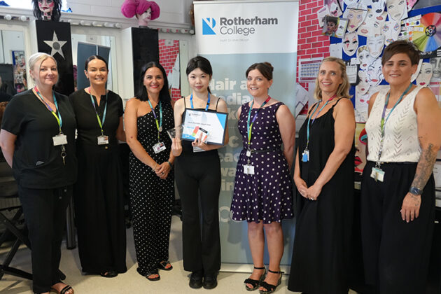 Seven females stood in a line in front of a Rotherham College pull up banner, the person in the centre is holding a certificate